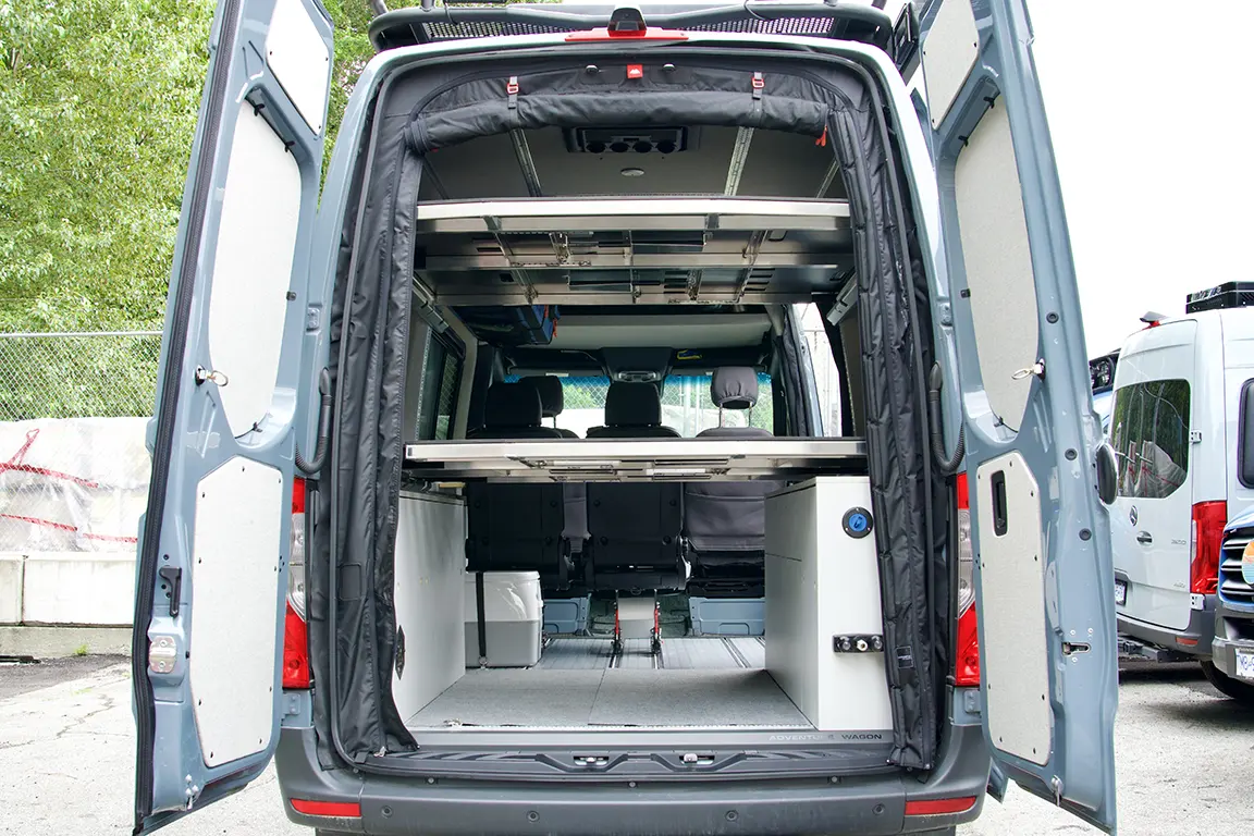 Mercedes Sprinter Van rear view with rear doors open showcasing the interior with double MOAB bed system, cabinets