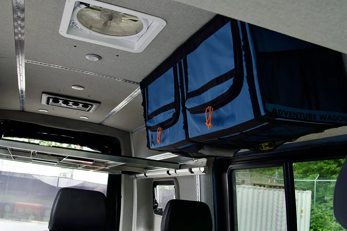 Van interior ceiling with Maxxfan, LED lights, Adventure Wagon Mule Bag overhead storage compartment, and aluminum framework